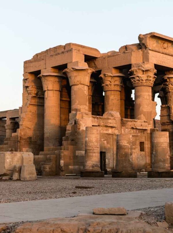 The Temple of Kom Ombo in Egypt, featuring detailed ancient stone columns and carvings, illuminated by soft evening light.