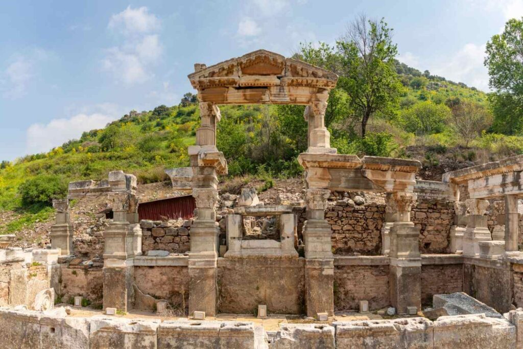 Ruins of the ancient Nymphaeum of Trajan in Ephesus, Turkey, showcasing columns and a partially preserved facade.