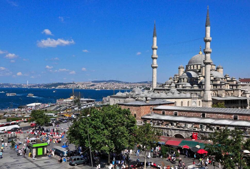 A stunning view of Istanbul featuring a grand mosque with tall minarets, busy streets, and the Bosphorus in the background.