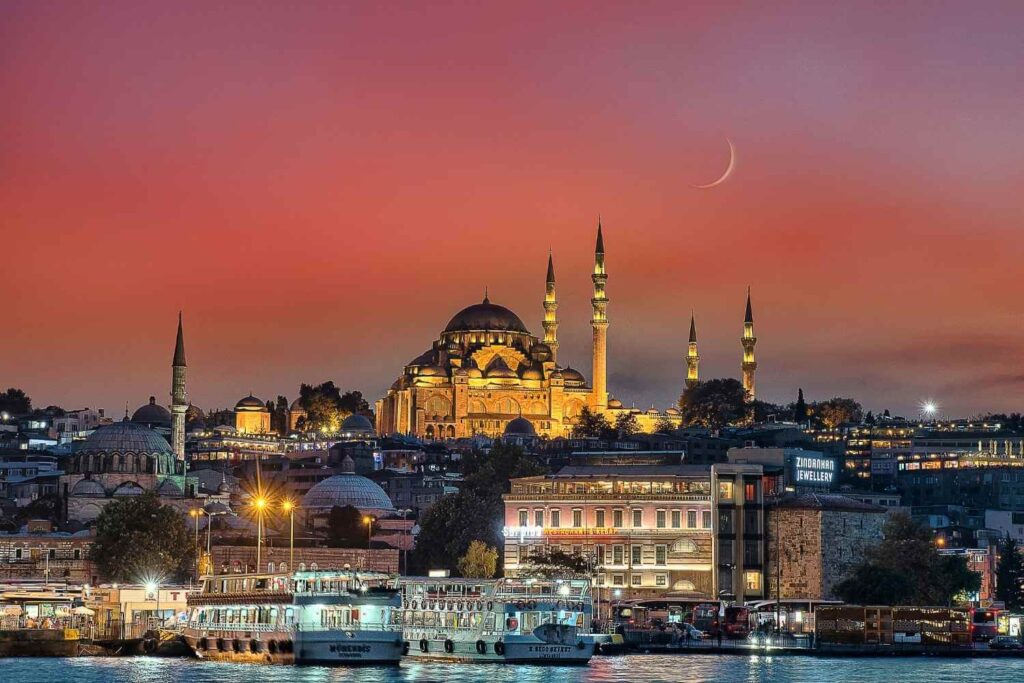 Suleymaniye Mosque at sunset in Istanbul, with golden hues illuminating its domes and minarets, showcasing Ottoman architecture.