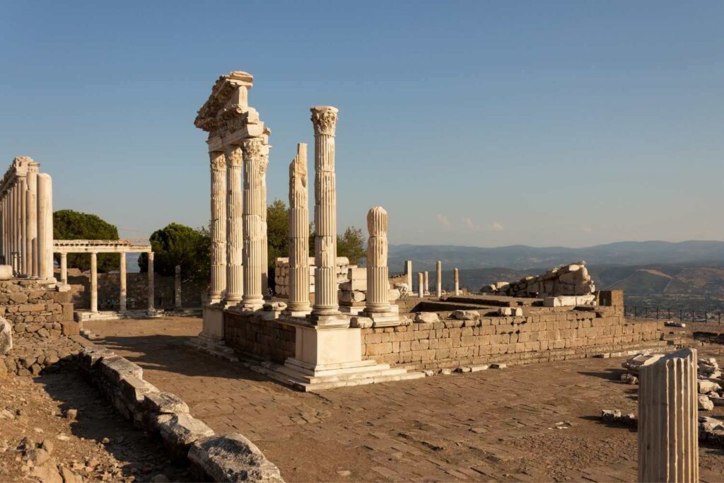 Ancient ruins of the Temple of Trajan in Pergamon, Turkey, featuring tall marble columns under a clear blue sky.